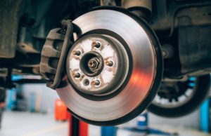 Close up of car disc brake during the wheel tire change or repair. Disc brake of the car during the maintenance at auto service garage.
